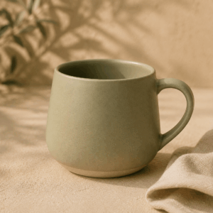 Mug Feuille en céramique vert sauge mat de 30 cl dans une ambiance naturelle.