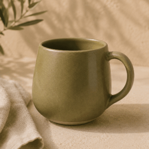Grand Mug Olive en céramique vert olive doux de 35 cl posé sur un fond minéral.